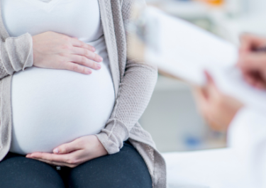 Ventre de femme enceinte avec un ours en peluche